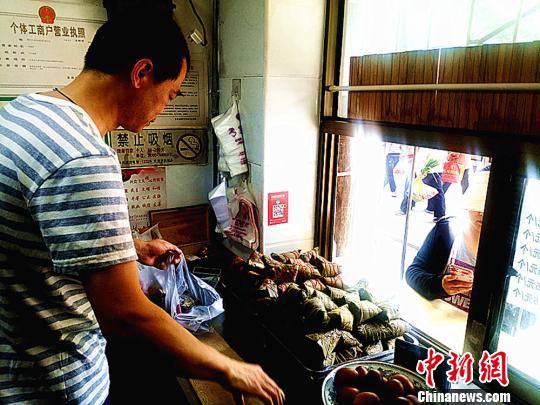 圖為凌君道正在將粽子裝袋進(jìn)行售賣。　高康迪 攝